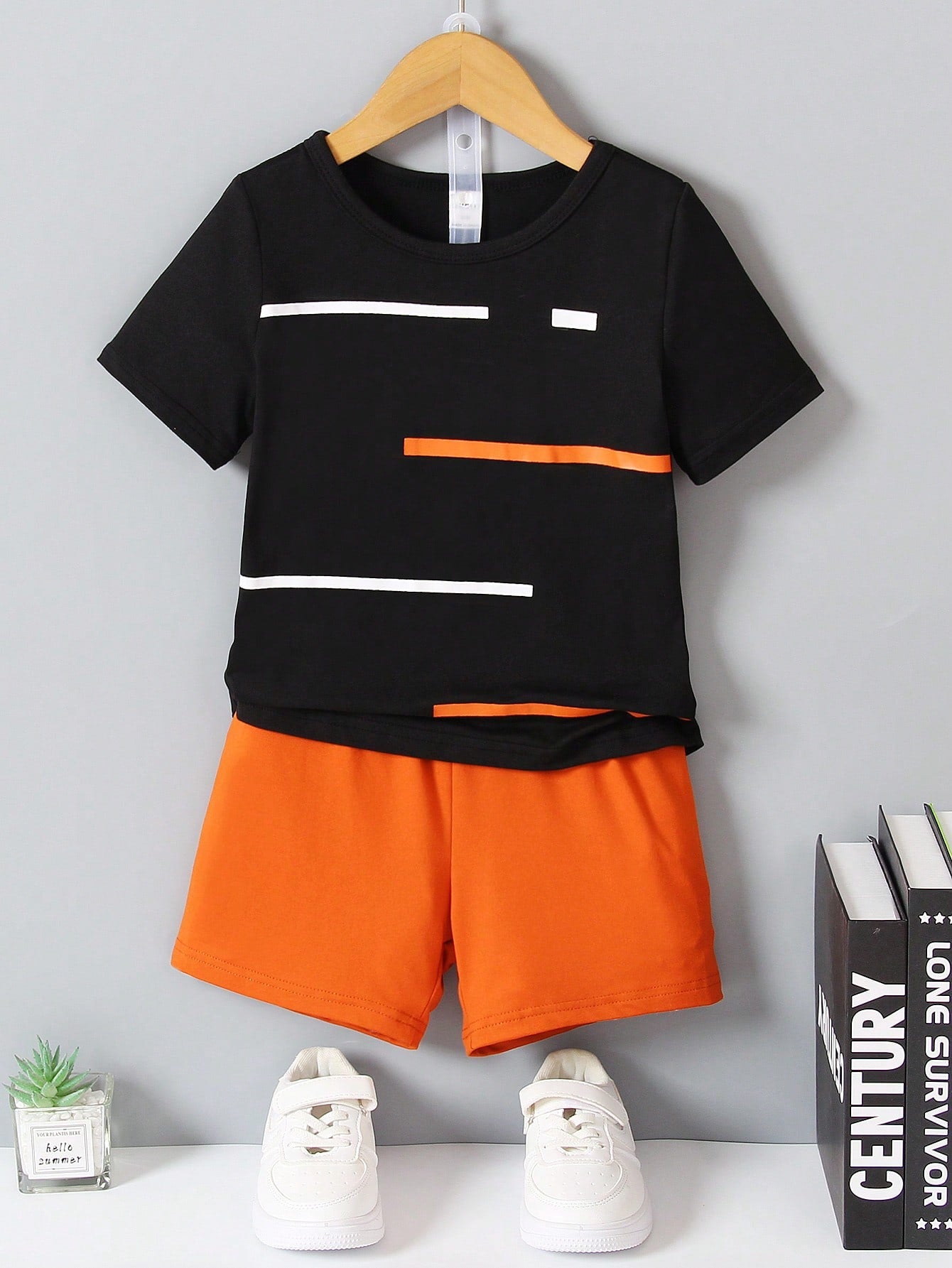 Young Boy Two-Piece Set. Yellow Knitted Striped Printed Round Neck Short Sleeves And Black Casual Knitted Sports Shorts. The Two-Piece Set Is Suitable For Summer.