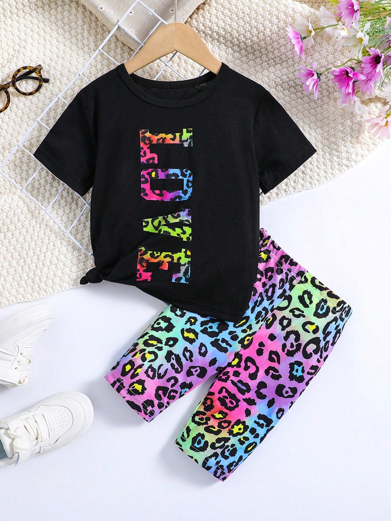 Young Girl Outfit Includes A White Short-Sleeved Round-Neck T-Shirt With Eye-Catching LOVE Letter Print And A Colorful Leopard Print Shorts. It Shows A Stylish And Personalized Style. The Large LOVE Letters On The White T-Shirt Highlight Uniqueness And Co