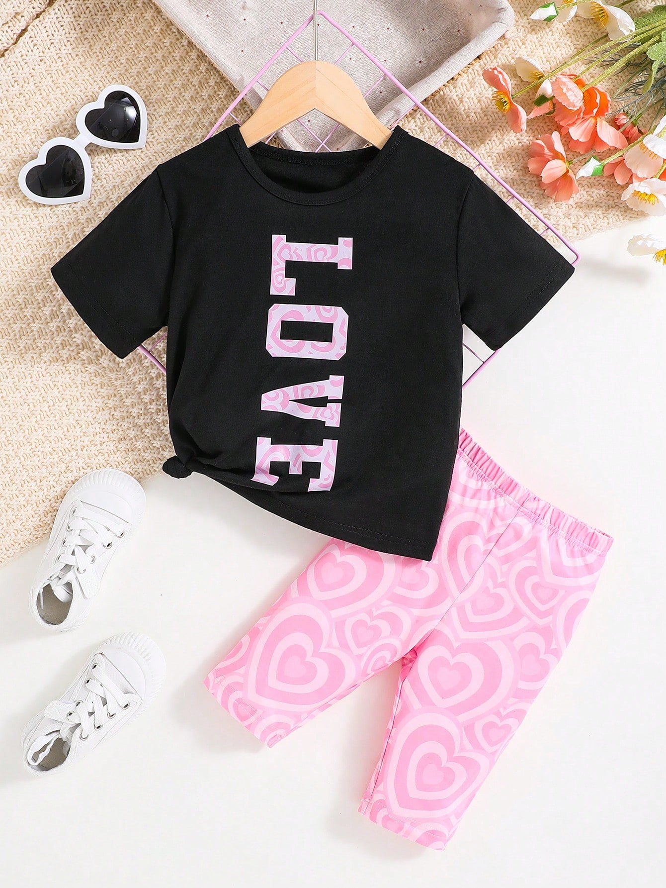 Young Girl Outfit Includes A White Short-Sleeved Round-Neck T-Shirt With Eye-Catching LOVE Letter Print And A Colorful Leopard Print Shorts. It Shows A Stylish And Personalized Style. The Large LOVE Letters On The White T-Shirt Highlight Uniqueness And Co