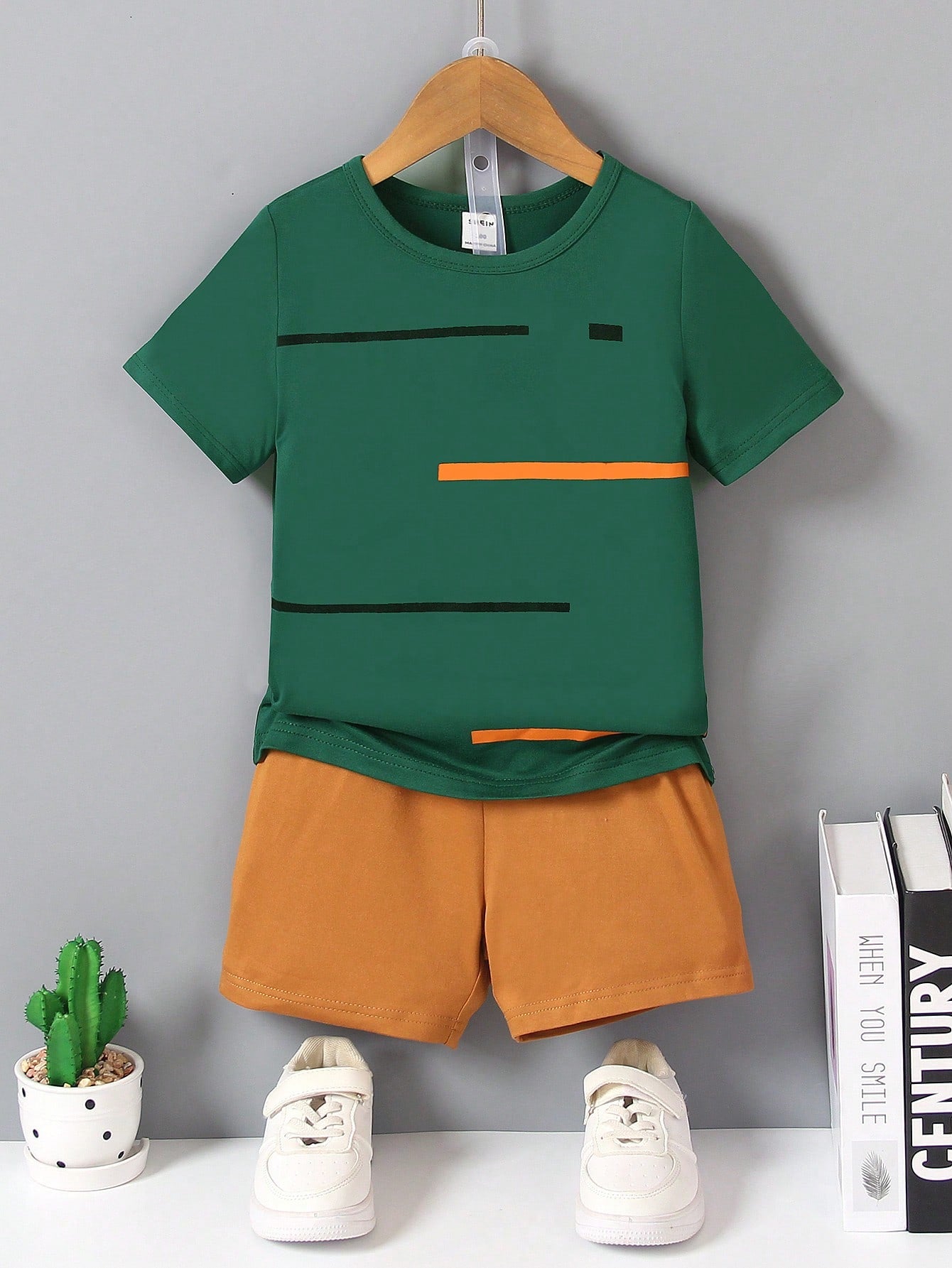 Young Boy Two-Piece Set. Yellow Knitted Striped Printed Round Neck Short Sleeves And Black Casual Knitted Sports Shorts. The Two-Piece Set Is Suitable For Summer.