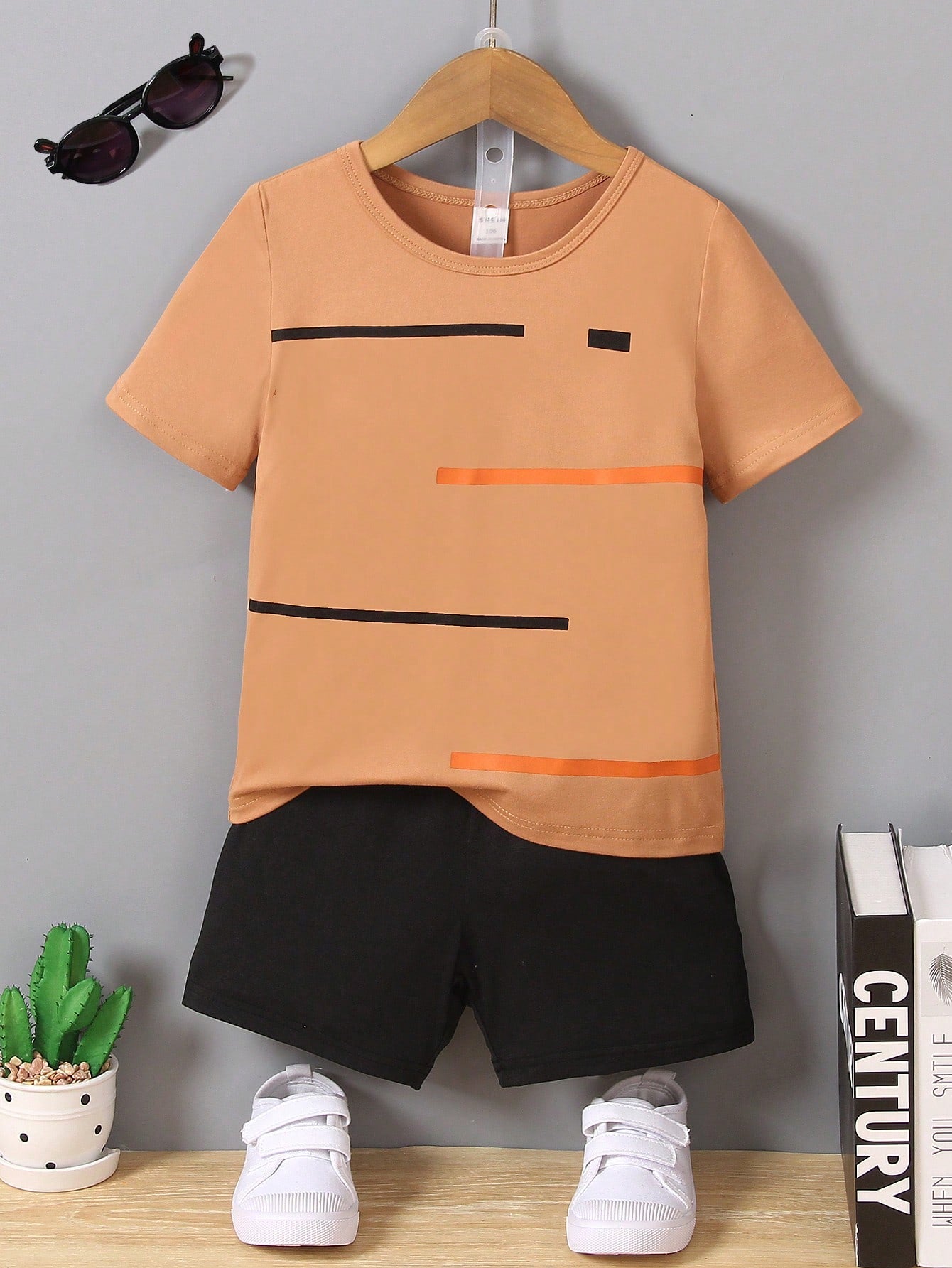 Young Boy Two-Piece Set. Yellow Knitted Striped Printed Round Neck Short Sleeves And Black Casual Knitted Sports Shorts. The Two-Piece Set Is Suitable For Summer.