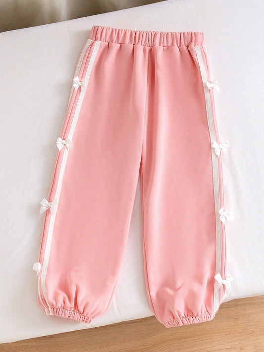 Little Girls' Pink Casual Pants, Decorated With White Side Tapes, Adding A Sporty Touch And A Retro Design Element. The Bow Design In The Middle Of The Tape Brings A Girlish And Playful Atmosphere. With Its Unique Side Design And Comfortable Wearing Exper