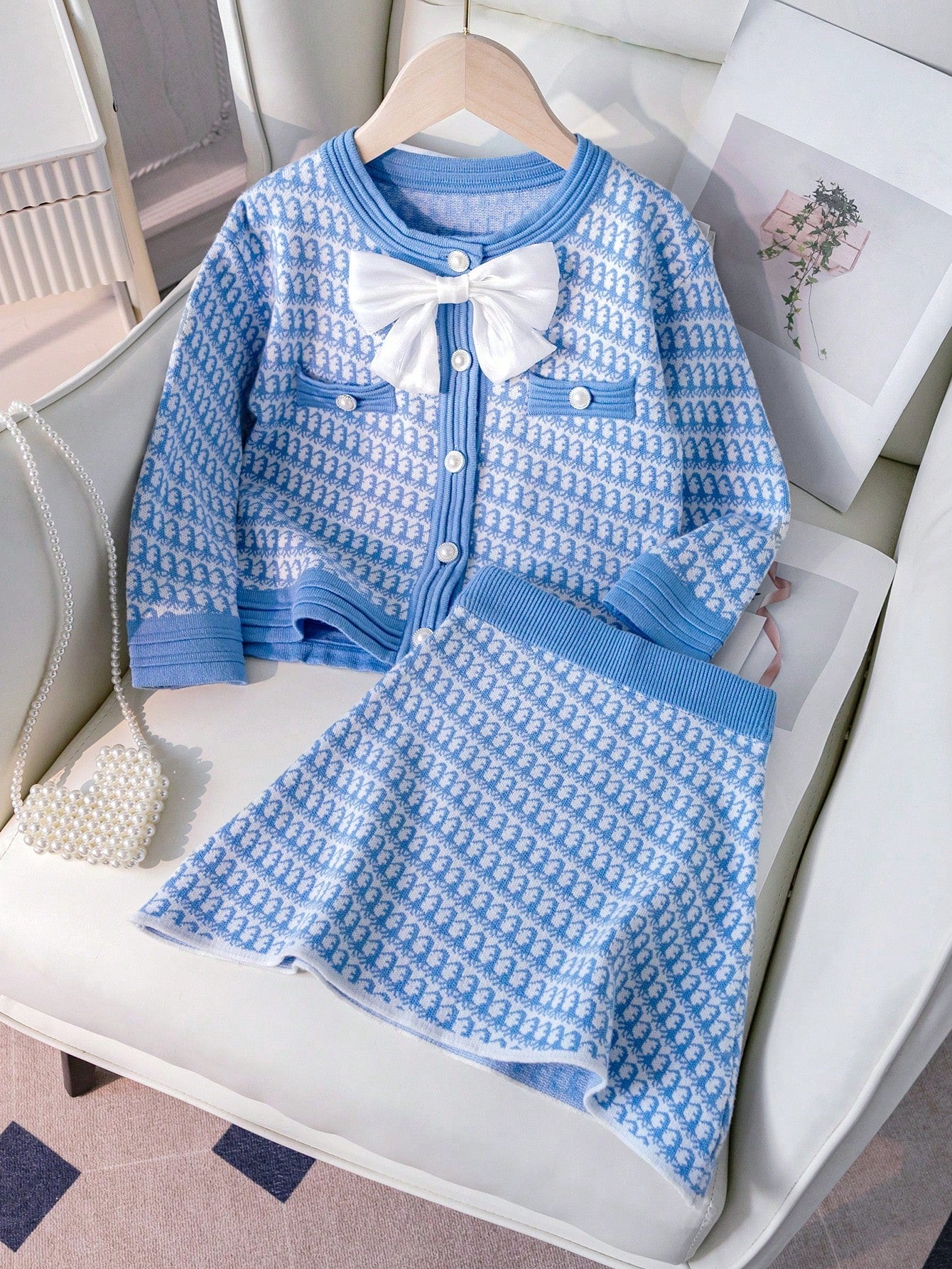 2pcs/Set Young Girl Knitted Cardigan Sweater And Mini Skirt Outfit, New Fashion For Fall/Winter. The Light Blue Soft Fabric And Gentle Pattern Make The Garment Elegant And Sweet. The Charming Bow Adds A Lively And  Touch. The Buttons Are Exquisite And Lux